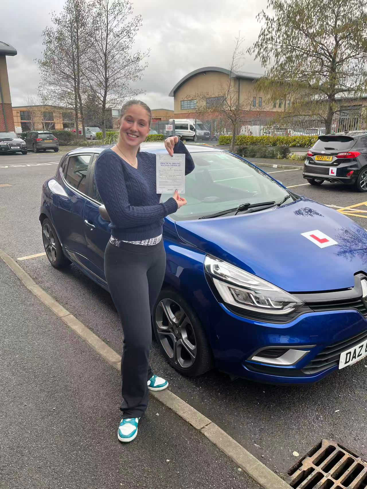 Smiling pupil with pass cert, DAZ plate visible on the car